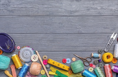 Photo of Flat lay composition with sewing threads and accessories on wooden background