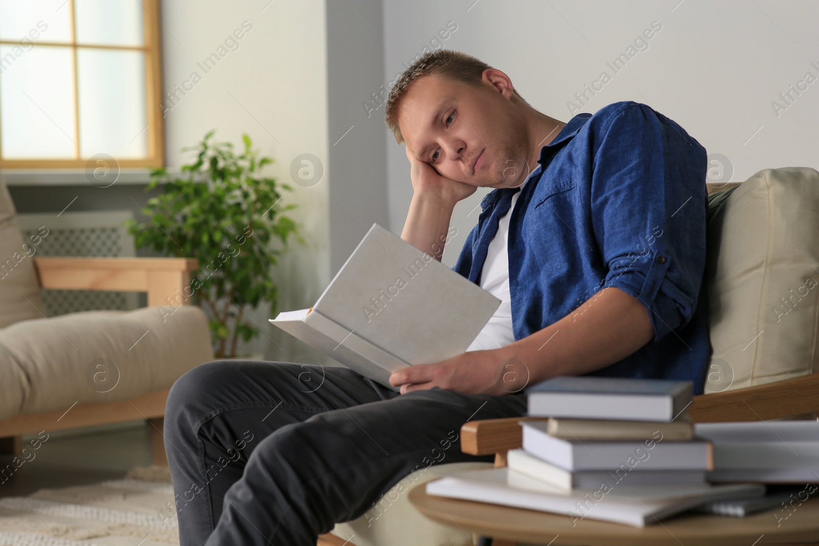 Photo of Tired man studying in armchair at home