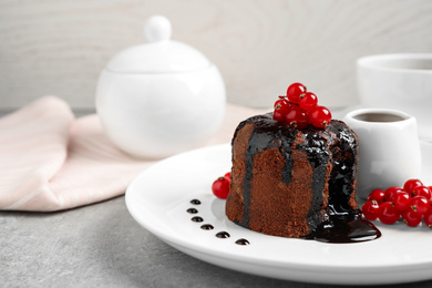 Photo of Delicious warm chocolate lava cake with berries on plate, closeup. Space for text