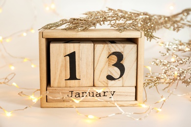 Photo of Wooden block calendar, decor and electric garland on table. Christmas countdown