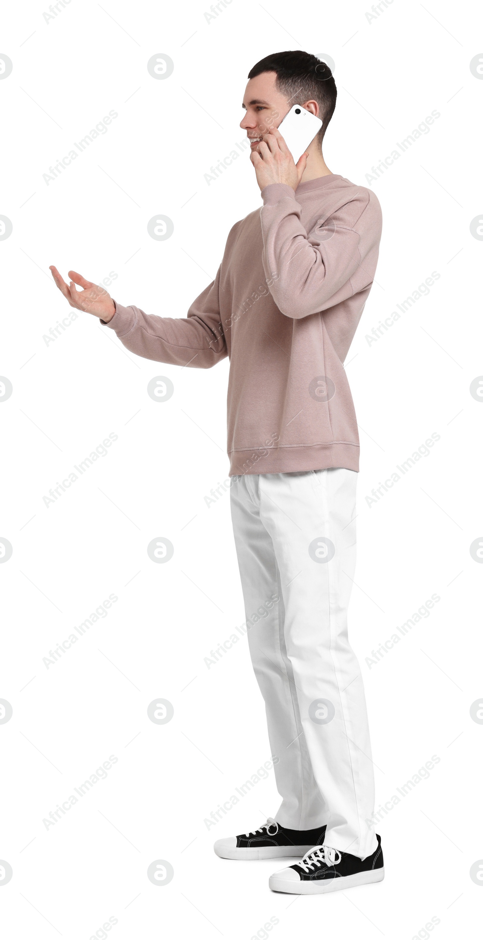 Photo of Handsome young man talking on phone against white background