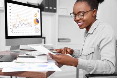 Professional accountant working at wooden desk in office