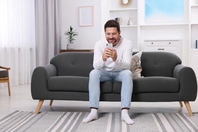 Happy man having video chat via smartphone at home