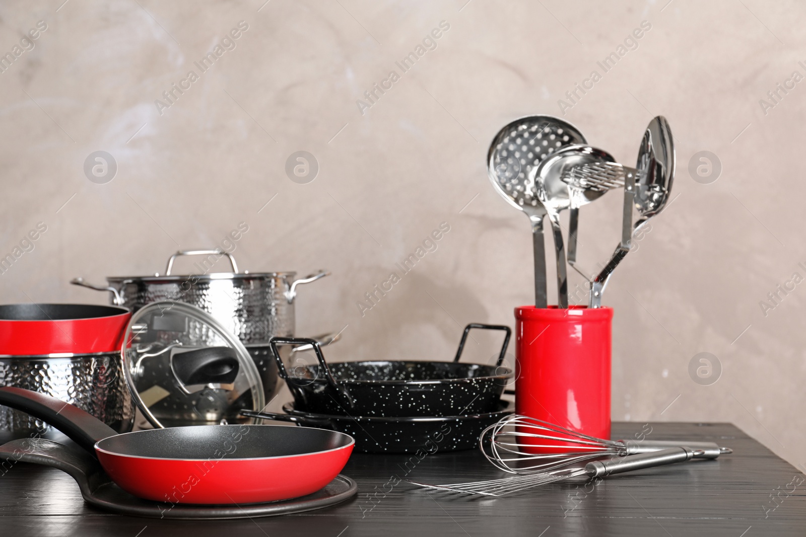 Photo of Set of clean cookware and utensils on table against color background, space for text