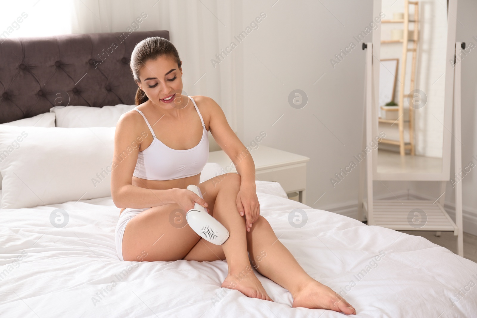 Photo of Woman doing leg epilation procedure on bed at home. Space for text