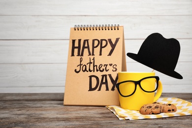 Photo of Composition with notebook, cup and glasses on wooden table. Father's day celebration