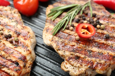 Photo of Delicious pork steaks and spices on grill pan, closeup