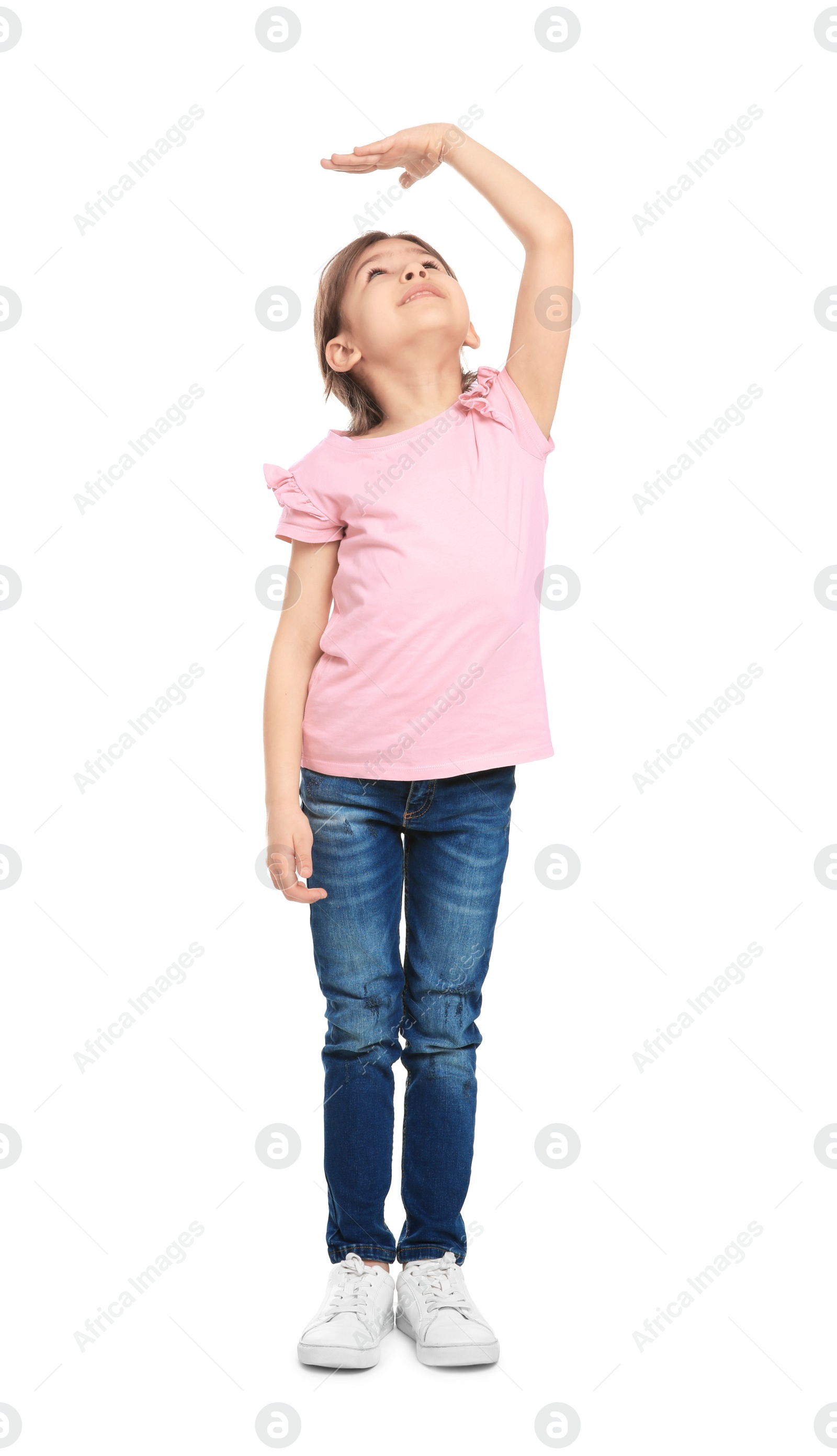 Photo of Little girl measuring her height on white background