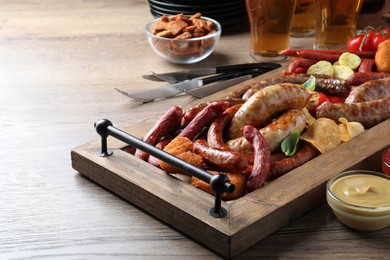 Set of different tasty snacks and beer on wooden table