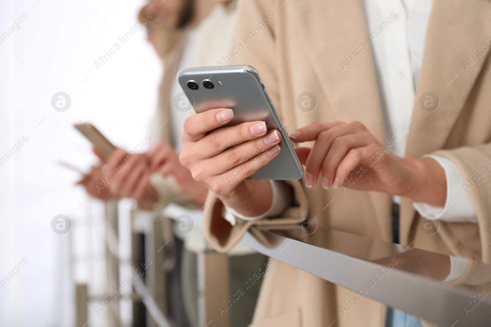 Photo of Young woman using modern smartphone indoors, closeup