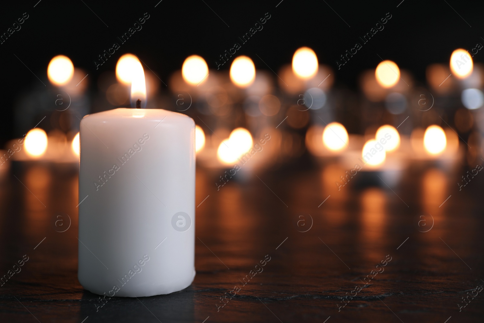 Photo of Burning candle on black table, space for text. Memory day