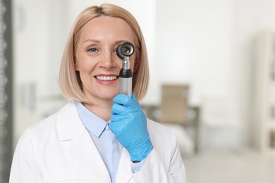 Professional dermatologist with dermatoscope on blurred background