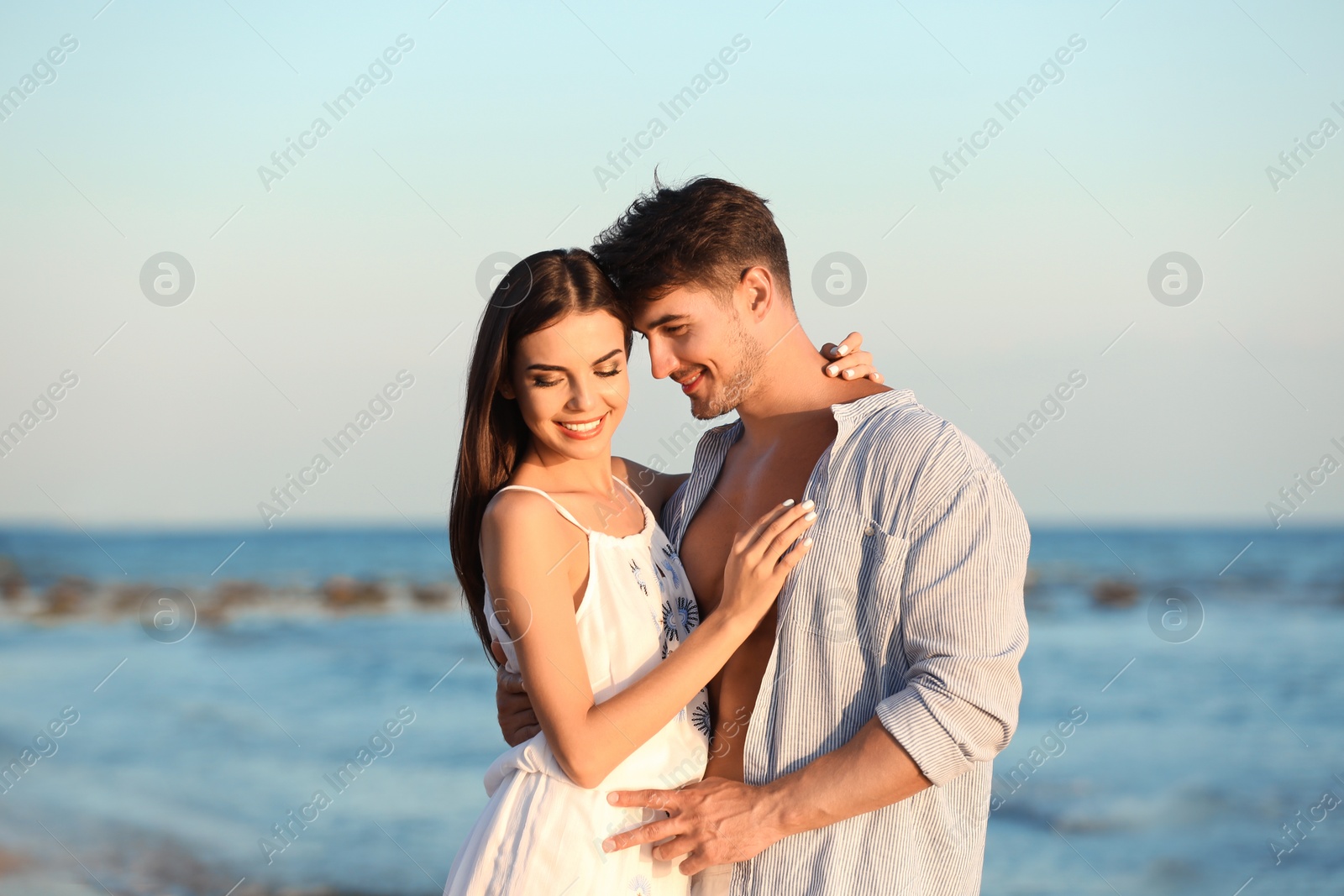 Photo of Happy young couple posing near sea on beach