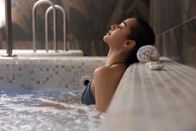 Photo of Beautiful woman relaxing in spa swimming pool, space for text