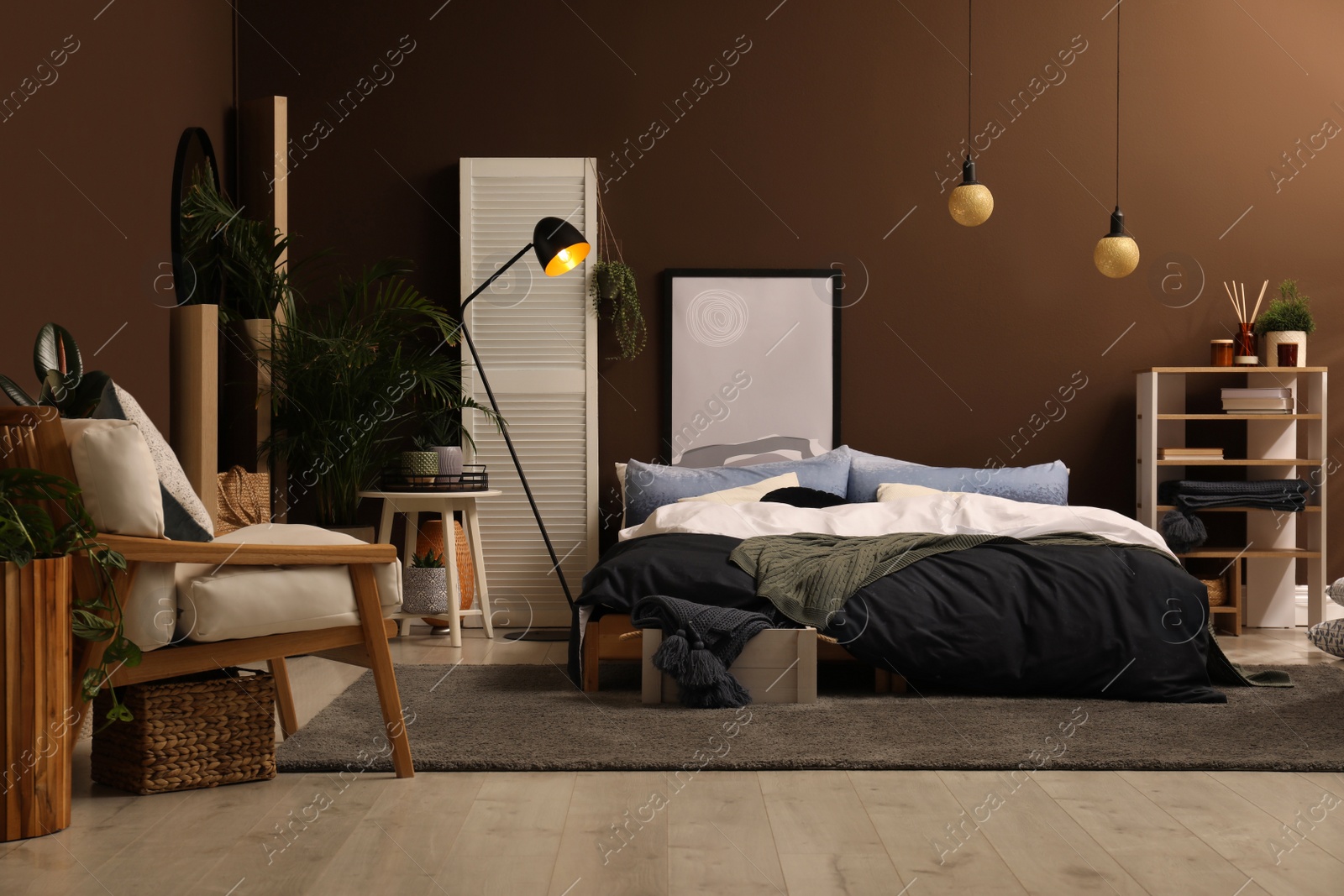 Photo of Stylish room interior with large bed near brown wall