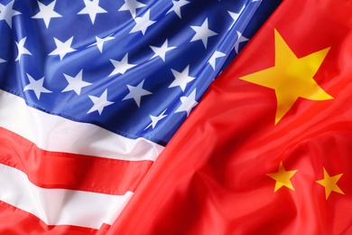 Photo of USA and China flags as background, top view. International relations