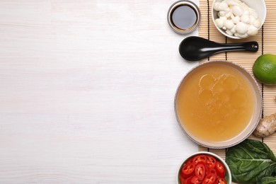 Photo of Cooking delicious ramen soup. Different ingredients and spoon on white wooden table, flat lay. Space for text