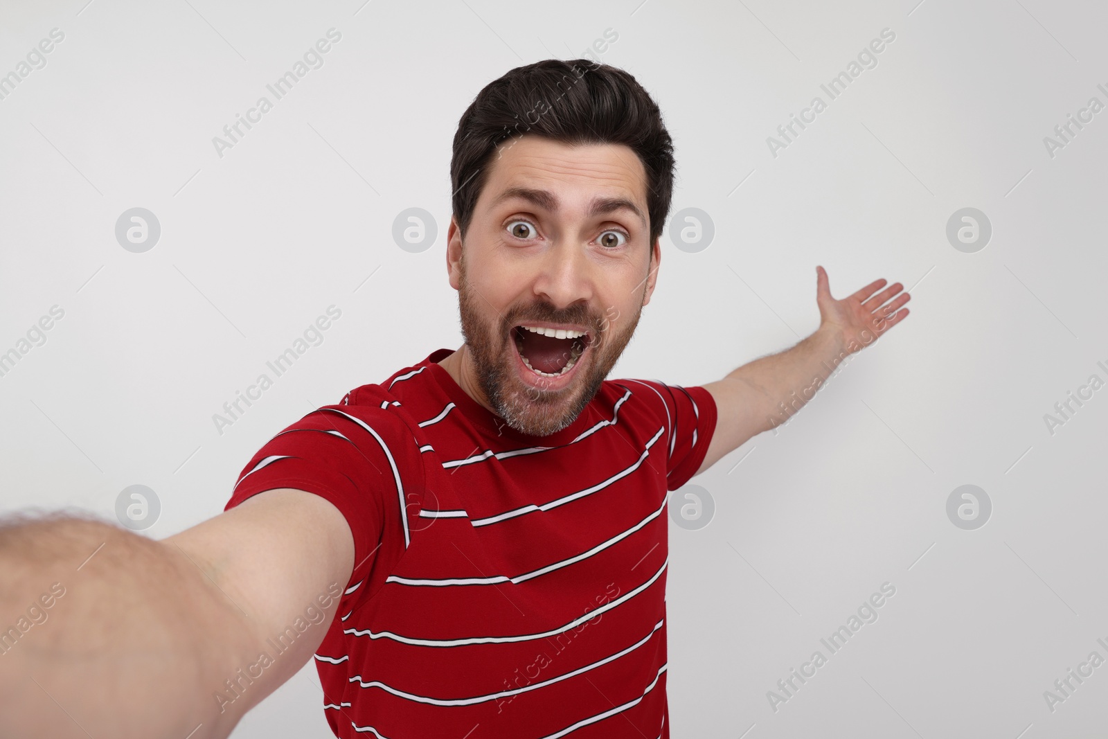 Photo of Smiling man taking selfie on white background