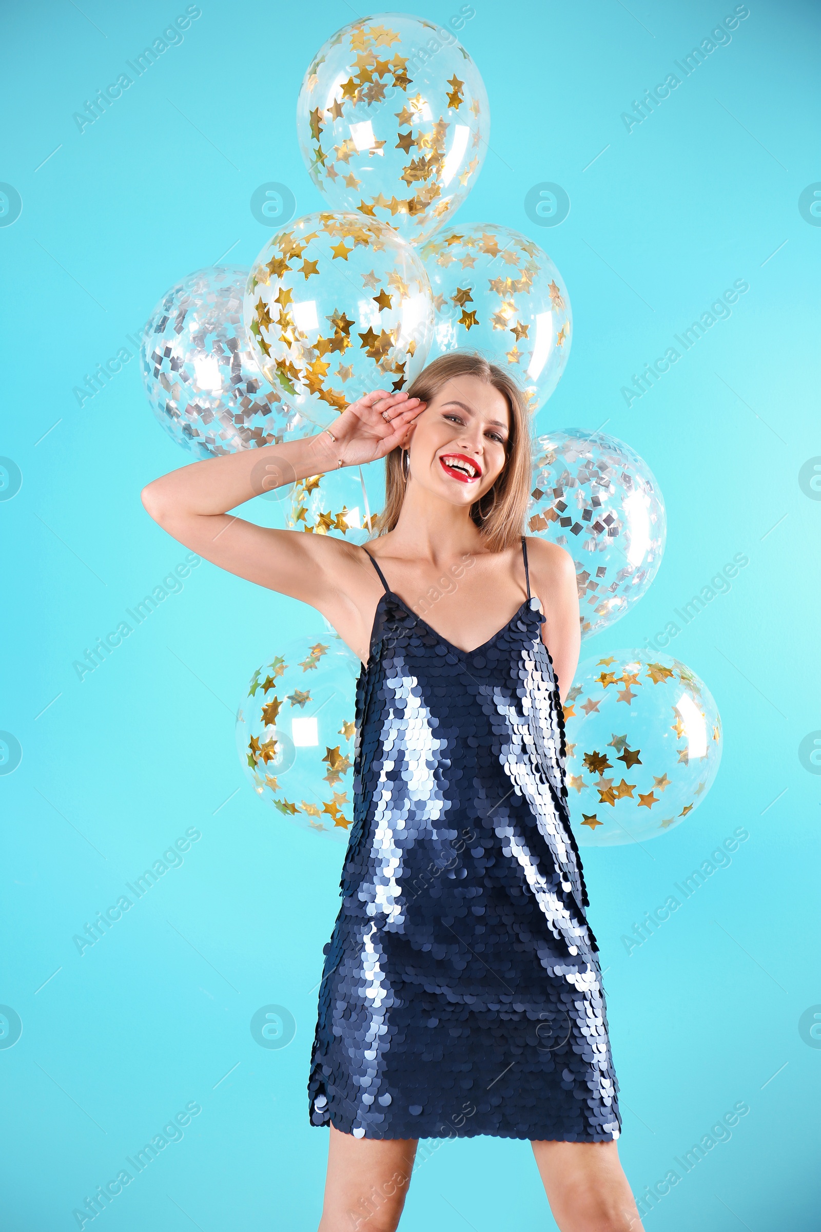 Photo of Young woman with air balloons on color background