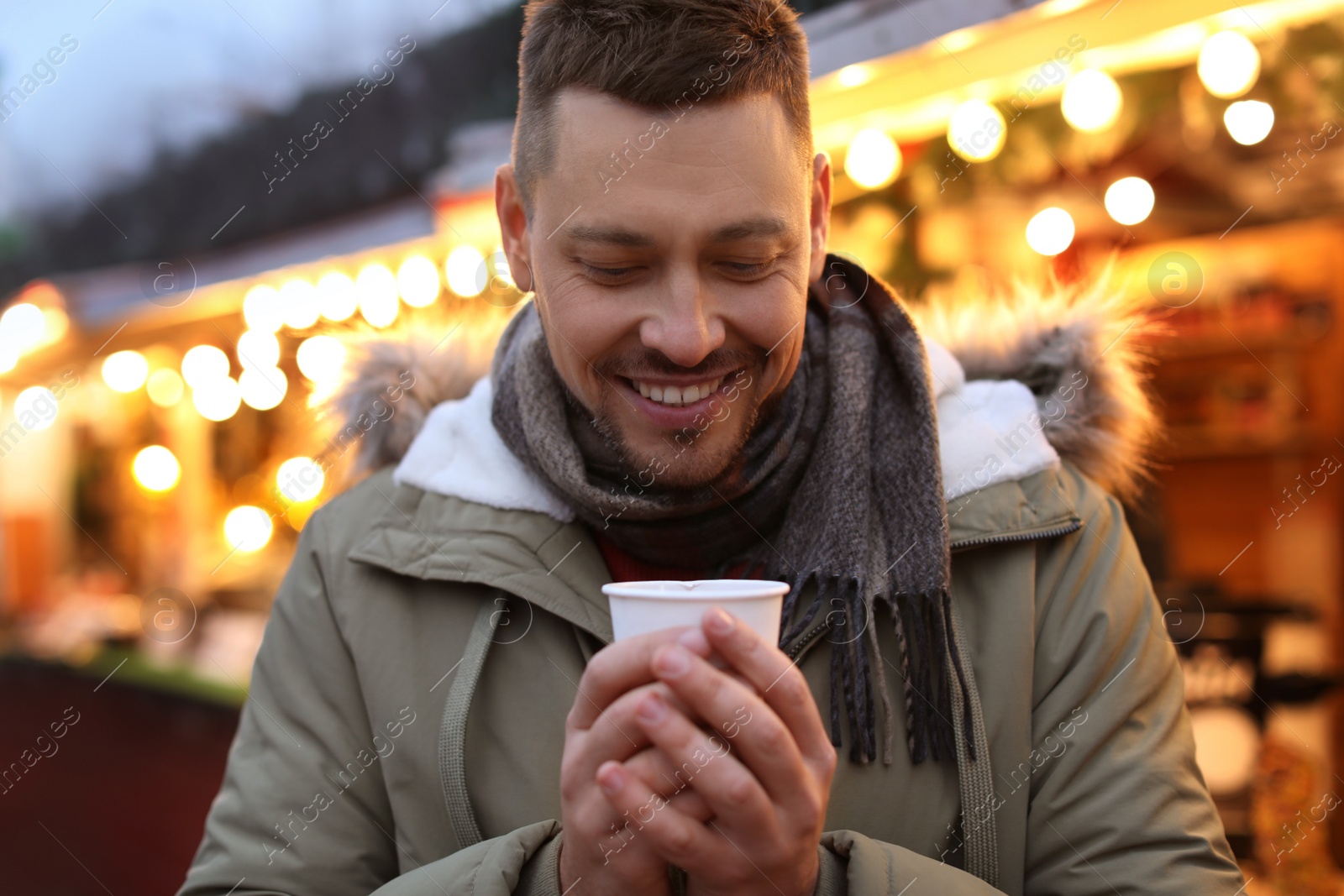 Photo of Happy man with mulled wine at winter fair