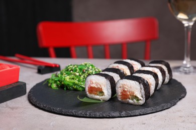 Photo of Tasty sushi rolls with salmon served on light table