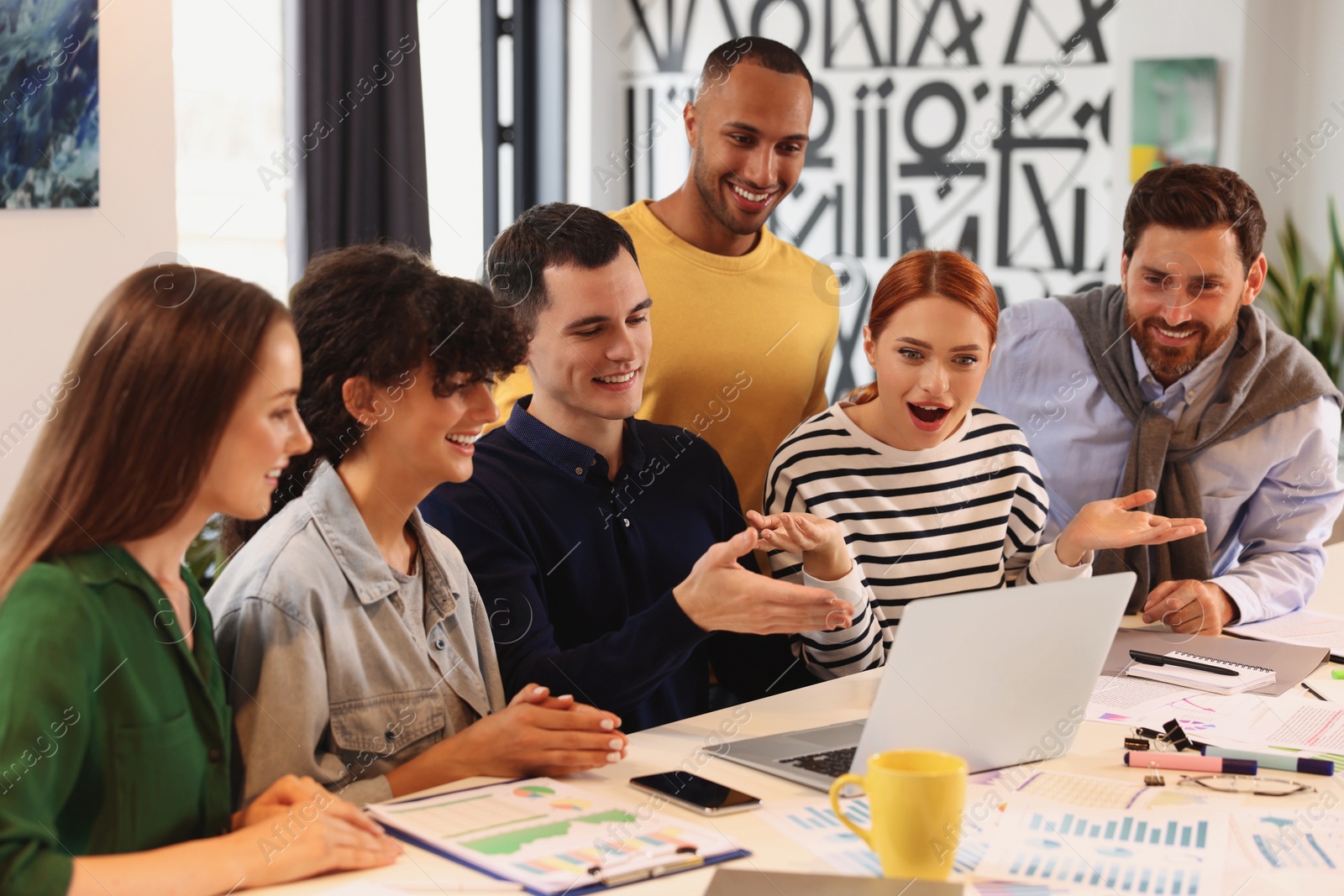 Photo of Team of employees working together at table in office. Startup project