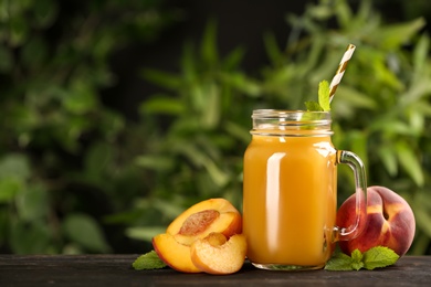 Natural peach juice and fresh fruits on wooden table. Space for text