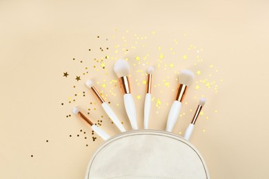 Flat lay composition with makeup brushes on beige background