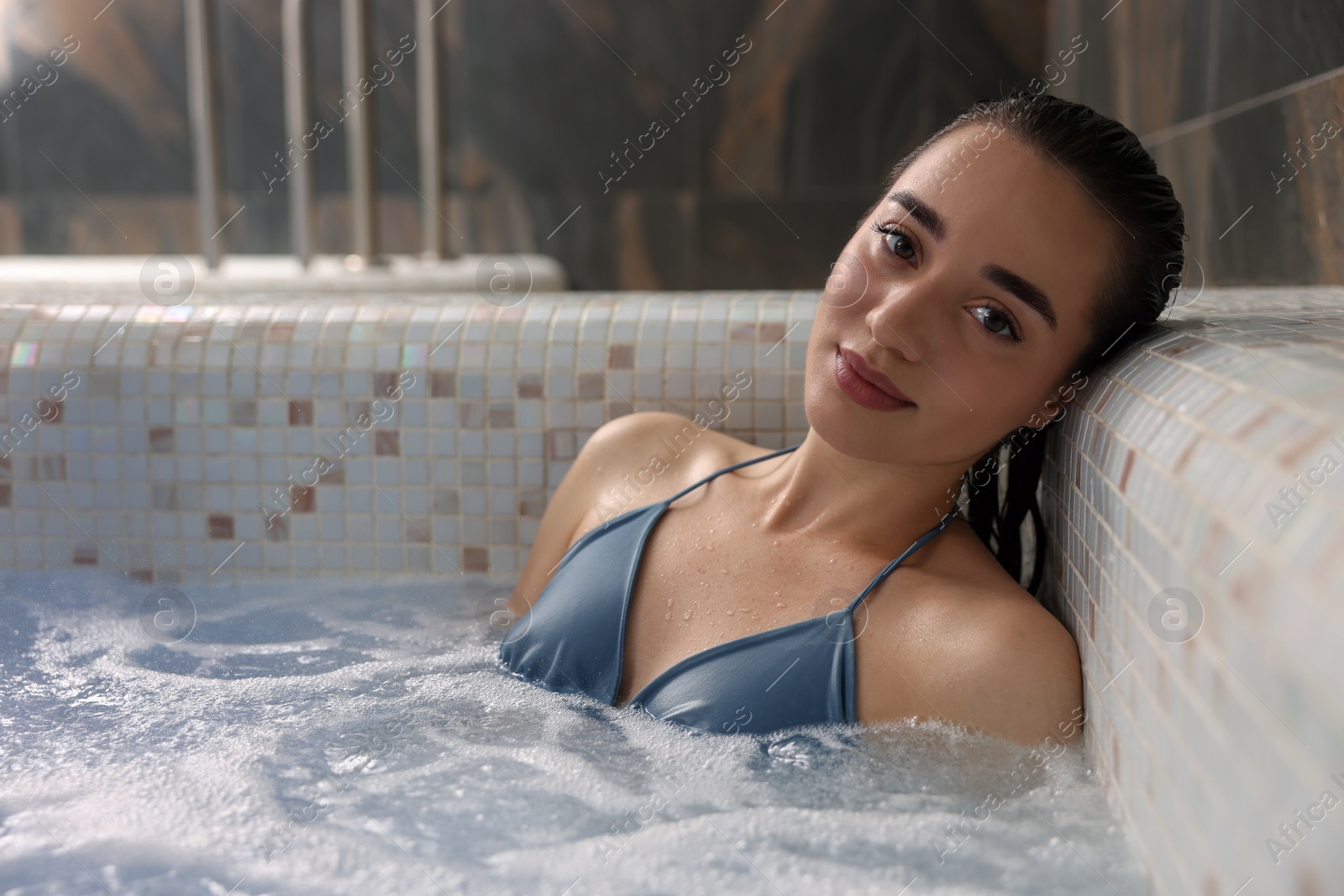 Photo of Beautiful woman relaxing in spa swimming pool, space for text