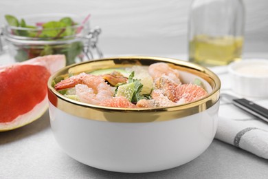 Delicious pomelo salad with shrimps served on light grey table, closeup