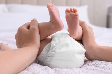 Mom with her baby in diaper at home, closeup