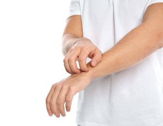 Photo of Young man scratching arm on white background, closeup. Annoying itch