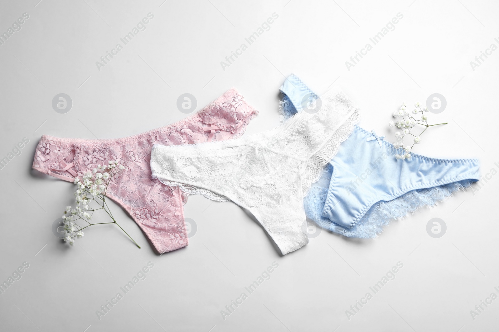 Photo of Women's underwear and flowers on white background, flat lay