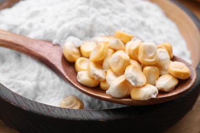 Photo of Bowl of corn starch and kernels on table, closeup