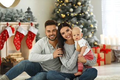 Photo of Happy family with cute baby at home. Christmas celebration