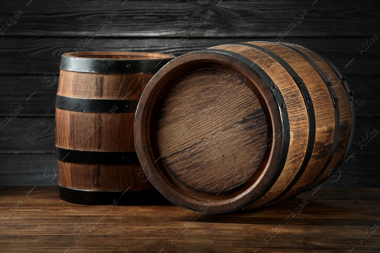 Photo of Two wooden barrels on table near wall