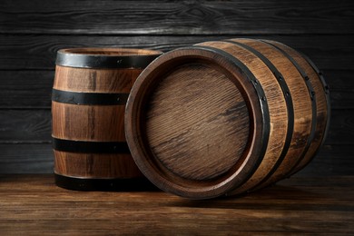 Two wooden barrels on table near wall