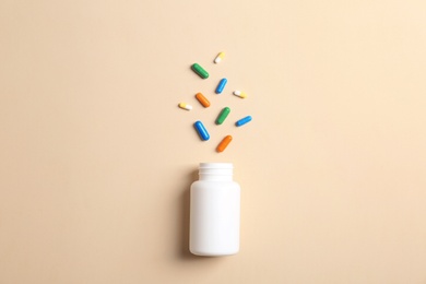 Flat lay composition with bottle and pills on color background