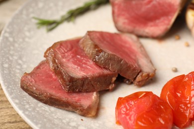 Photo of Delicious grilled beef steak with tomatoes on plate, closeup