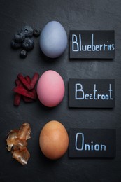 Photo of Naturally painted Easter eggs on black table, flat lay. Blueberries, beetroot and onion used for coloring