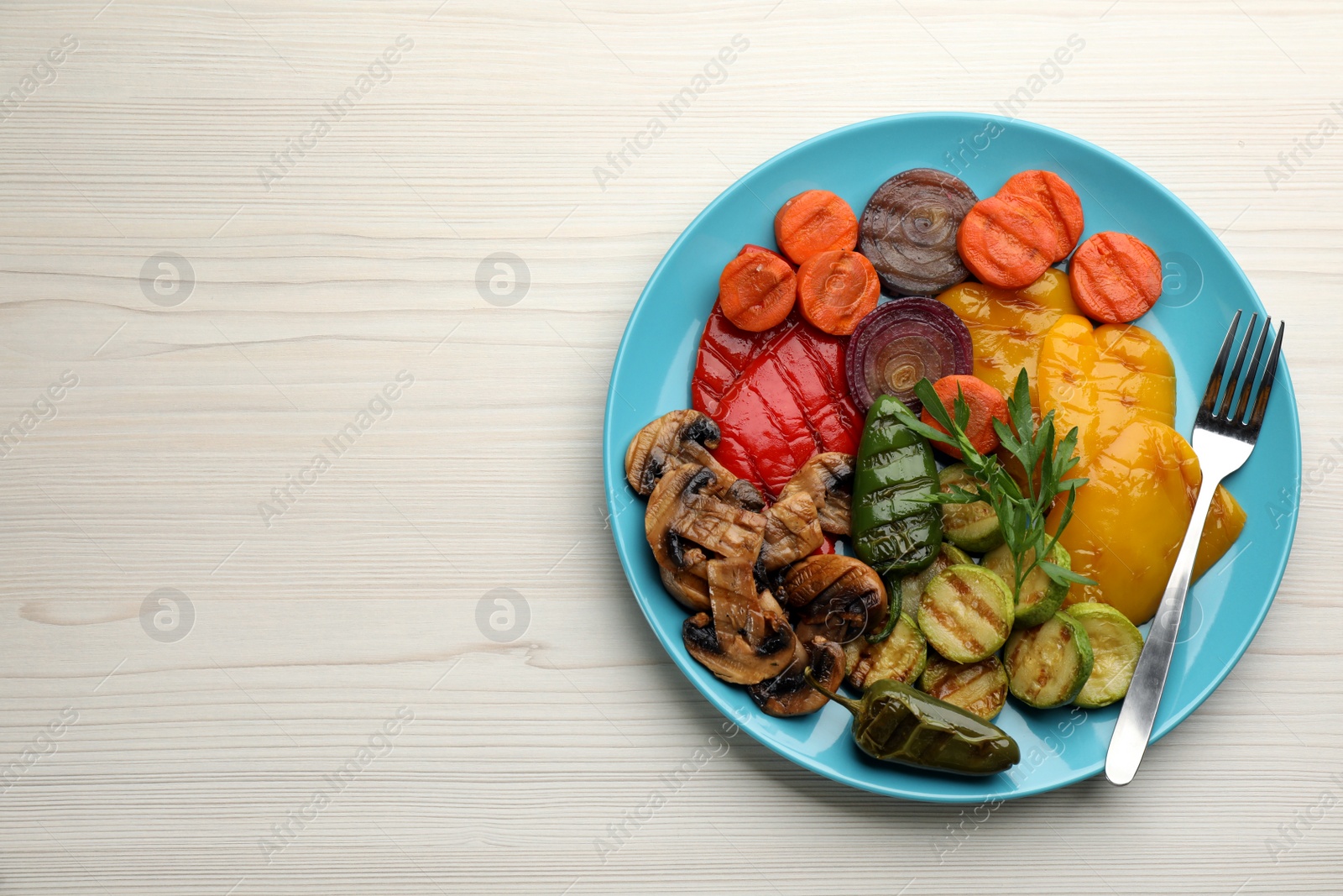 Photo of Delicious grilled vegetables on white wooden table, top view. Space for text