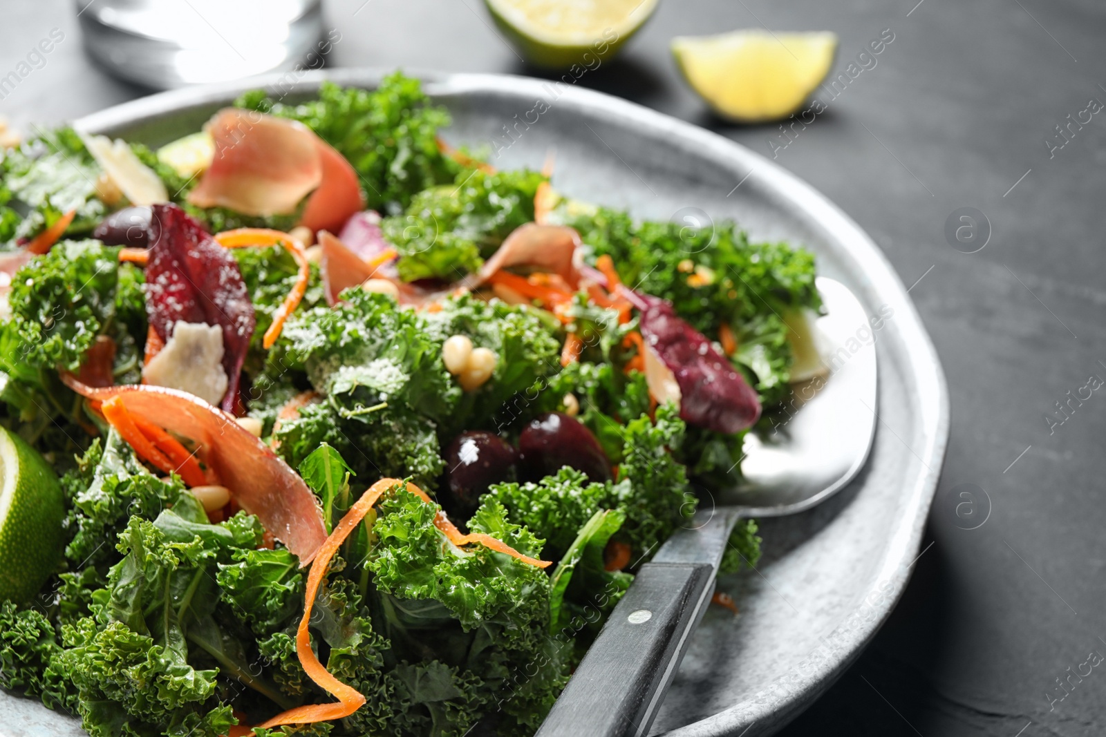 Photo of Tasty fresh kale salad on grey table, closeup