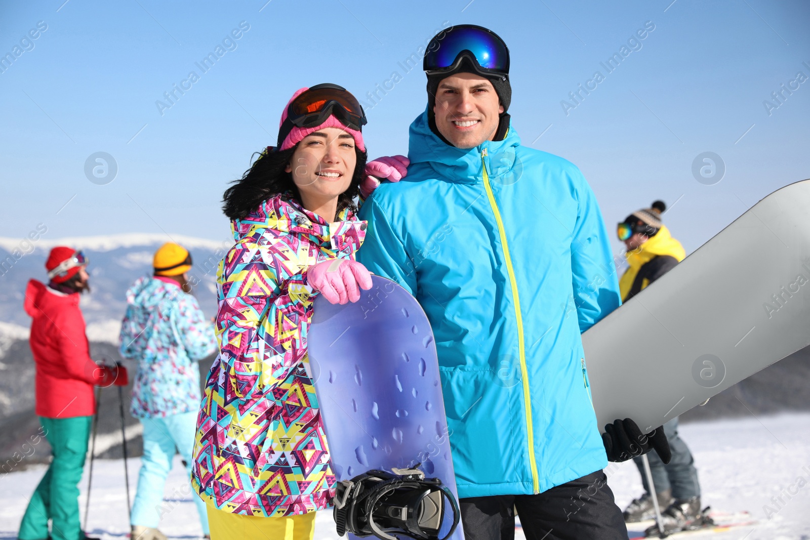 Photo of Couple with snowboards at ski resort. Winter vacation