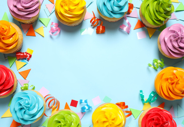 Colorful birthday cupcakes on light blue background, flat lay. Space for text