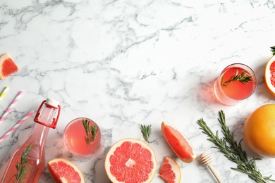 Photo of Flat lay composition with grapefruits, glasses of cocktails and bottle on marble background. Space for text