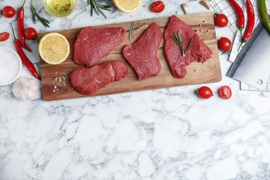 Photo of Fresh raw meat steaks and spices on white marble table, flat lay. Space for text