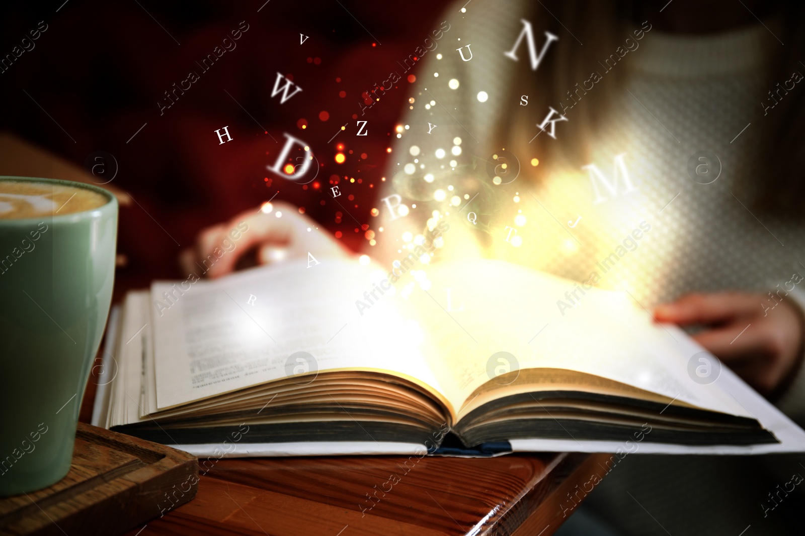 Image of Woman reading shiny magic book with letters flying over it, closeup