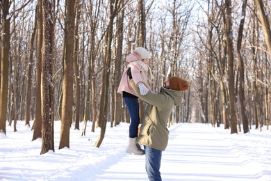 Family time. Father playing with his daughter in snowy forest