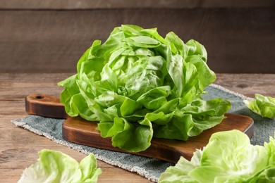 Photo of Fresh green butter lettuce on wooden table, closeup