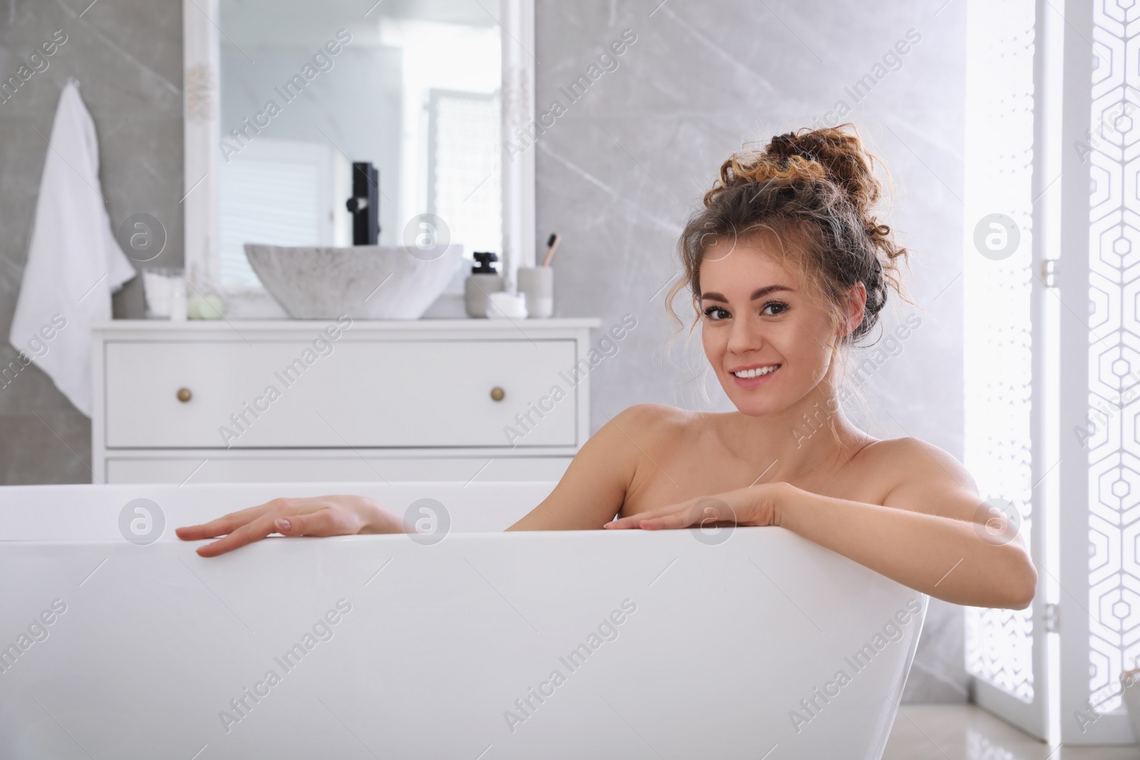 Photo of Beautiful woman relaxing in bathtub at home